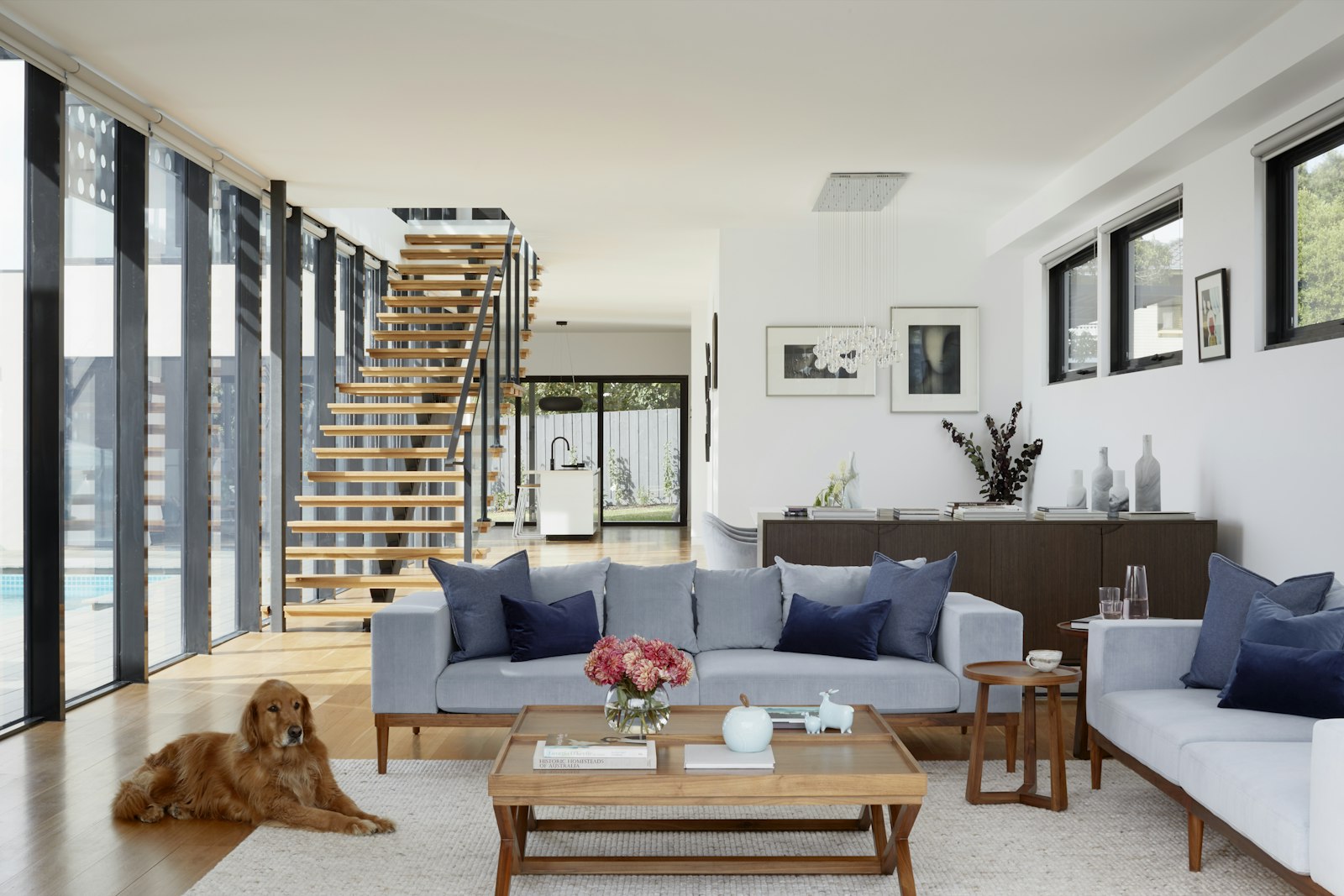 A finished open living room with a floating wood staircase, the result of a home addition